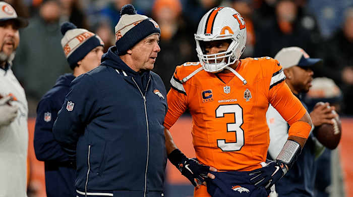Denver Broncos head coach Sean Payton speaks with quarterback Russell Wilson during a game.